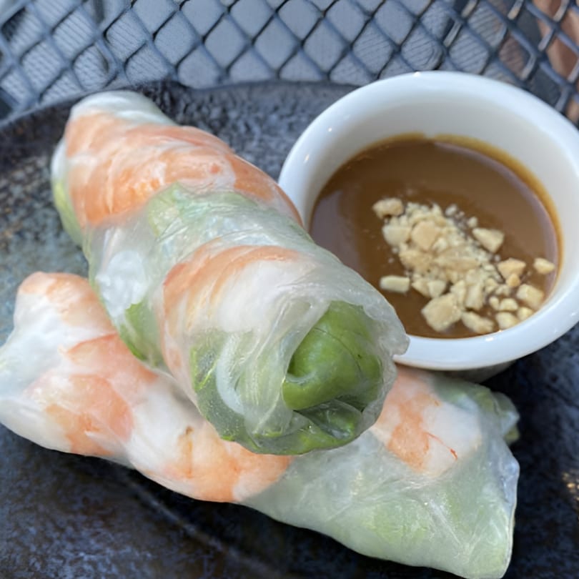 Two fresh Vietnamese spring rolls with shrimp and greens, served with peanut dipping sauce.