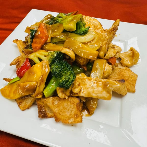 Chicken with broccoli, carrots, and bell peppers in a savory sauce, served over crispy wontons.