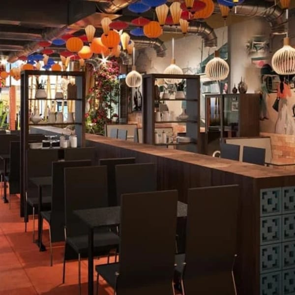 Interior of Viet Chopsticks DC restaurant with colorful lanterns, dark tables, and chairs.